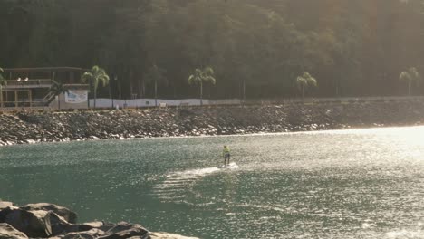 Un-Paddleboarder-Disfrutando-De-Su-Rutina-Matutina-De-Ejercicios-Remando-Alrededor-De-La-Bahía-De-Panamá,-El-Hermoso-Sol-De-La-Mañana-Reflejándose-En-Las-Aguas-Tranquilas,-Ciudad-De-Panamá