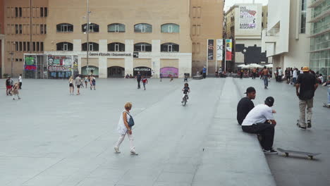 Barcelona---Plaça-dels-Àngels,-outside-the-Museum-of-Contemporary-Art-with-skateboarders-and-cyclists