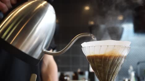 Perfect-loop-cinemagraph-of-barista-brewing-V60-filter-coffee,-hand-pour-over-using-a-stainless-steel-goose-neck-kettle