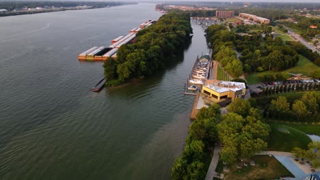 Aerial-drone-view-towards-a-harbor-on-the-shore-of-the-Ohio-river,-sunset-in-Louiseville,-USA