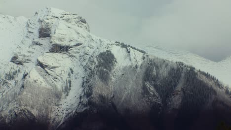 Pico-De-Montaña-Con-Bandada-De-Pájaros-Y-Nieve-Ligera