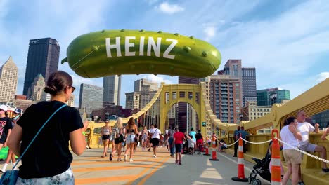 People-walking-on-the-Andy-Warhol-Bridge-with-giant-Heinz-pickle-balloon-in-the-background