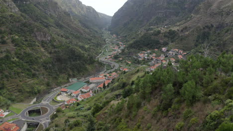 Frau-Bewundert-Tagsüber-Die-Malerische-Stadt-Am-Fuße-Des-Grünen-Berges-Auf-Der-Insel-Madeira,-Portugal