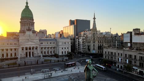 Pedestal-shot-of-two-congresses-monument-in-the-foreground-at-congressional-plaza-with-Palace-of-the-Argentine-National-Congress-and-Confiteria-del-Molino-in-the-background,-Buenos-Aires-at-sunset