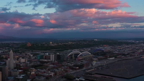 Big-aerial-shot-pulling-away-from-Seattle's-Stadium-District-with-a-cool-pink-sunset-in-the-background