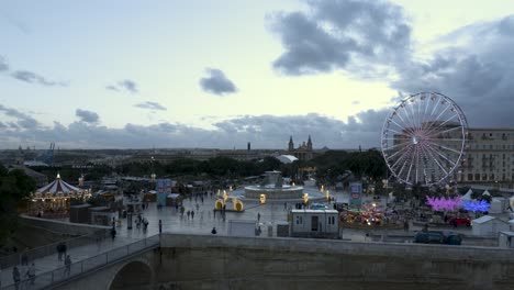 Winter-wonderland-timelapse-overlooking-entrance-to-Valletta,-turned-into-a-Christmas-village-with-a-giant-Ferris-wheel-and-an-other-Christmas-rides