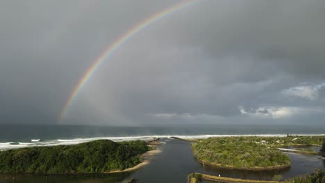 Large-colorful-rainbow-located-on-a-scenic-coastal-river-inlet-near-a-popular-holiday-spot