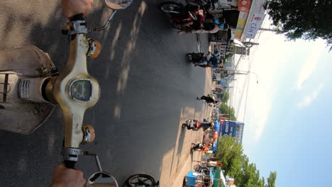 Vertical-video,-POV-riding-an-old-Honda-cub-motor-scooter-on-busy-street-Vietnam,-town-center-in-Mui-ne