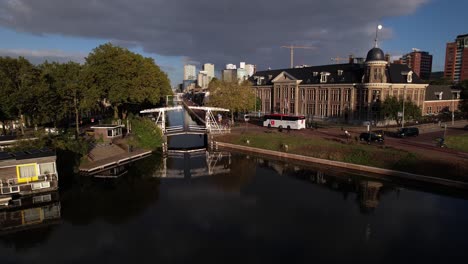 Aerial-approach-showing-Muntgebouw-museum-in-Utrecht-with-small-white-draw-bridge-over-the-canal-in-front-on-a-bright-sunny-day-with-cloud-formation-in-the-background