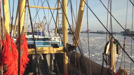 POV-fishing-boat-preparing-to-dock-in-a-frozen-harbor-on-a-sunny-winter-day