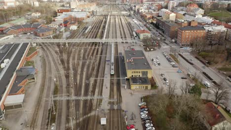 Aerial-view-of-passenger-train-arriving-at-Turku-railway-station-during-rush-hour,-passengers-disembarking