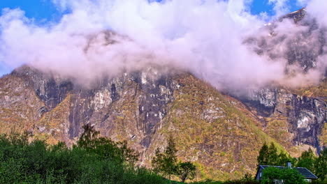 Time-lapse-shot-of-hovering-clouds-and-fog-between-mountains-during-sunny-day-in-summer---Green-Leaves-of-Trees-in-the-valley