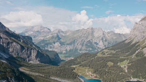 Dolly-forward-drone-shot-over-Blue-Lake-Oeschinen-towards-Kandersteg-Swiss-mountains