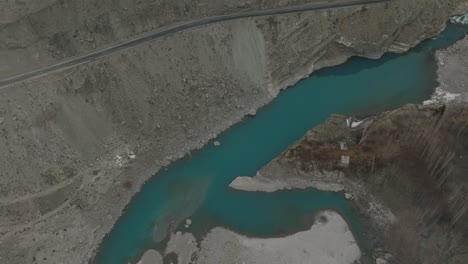 Aerial-Over-Calm-Turquoise-River-Water-In-Hunza-Valley-Beside-Road