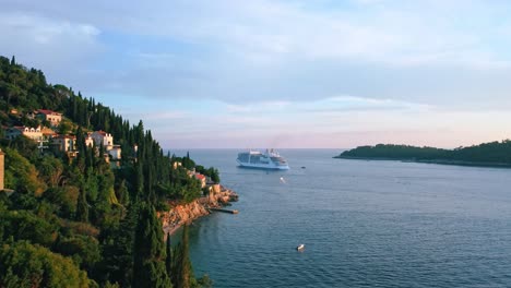 Aerial-shot-of-a-luxury-cruise-ship-on-the-coast-of-a-beautiful-European-beach