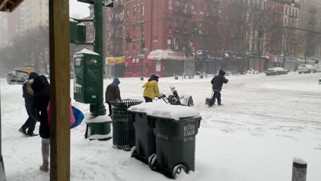 Männer-überqueren-Die-Straße-Mit-Schneeschaufeln-Und-Schneefräse-Im-New-Yorker-Schneesturm