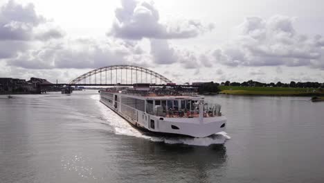 Viking-Ve-Cruise-Longship-Navegando-A-Lo-Largo-Del-Río-Noord-Con-Brug-Over-De-Noord-En-El-Fondo