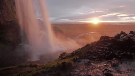 Island-Wasserfall-Mit-Sonnenuntergang-Im-Hintergrund-In-Zeitlupe