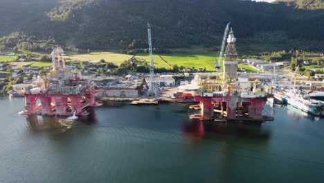 Two-drilling-rigs-alongside-in-Olen-Norway---Rigs-left-with-no-work-due-to-climate-change-debate---Sunny-day-aerial-showing-two-Transocean-rigs-at-Westcon-Norway