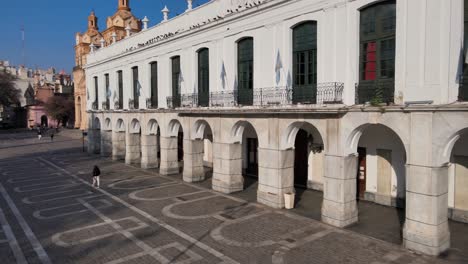 Aerial-pan-shot-capturing-quiet-square-and-Cordoba-Cabildo-colonial-town-hall-with-iconic-arch-passageway-at-San-Martin-plaza-in-downtown-city