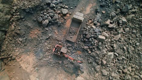 Vista-De-Dron-Giratorio-Superior-De-La-Excavadora-Carga-Mineral-En-Un-Gran-Camión-Volquete-Minero