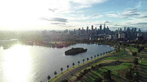 Panorámica-Suave-Y-Decente-Sobre-El-Lago-Albert-Park-Que-Muestra-Melbourne-Cbd-Bajo-Una-Gloriosa-Luz-Brillante