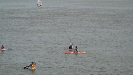 Several-Vacationists-SUP-Paddle-Boarding-On-Han-River-At-Summer-In-Seoul,-South-Korea