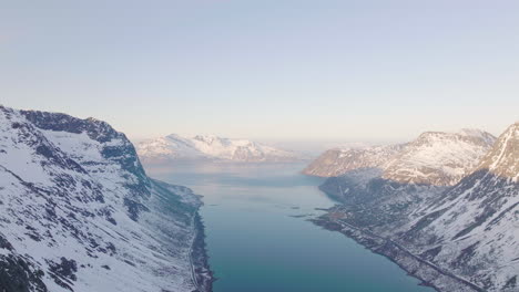 High-altitude-drone-view-of-snow-covered-alpine-landscape-of-fjord