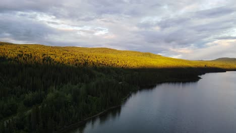 Wunderschönes,-Sanftes-Sonnenlicht,-Das-Auf-Die-Spitze-Eines-Waldes-Trifft,-Der-Den-Dease-Lake-In-British-Columbia,-Kanada,-Umgibt