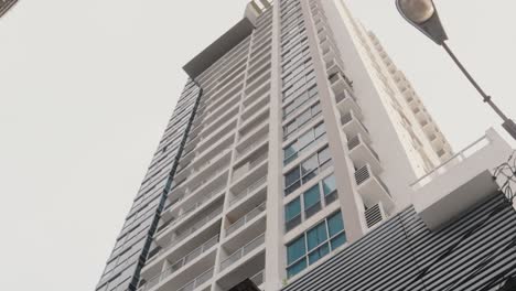 A-steep-vertical-tilt-pan-of-a-tall-residential-condominium,-prime-luxury-real-estate-in-the-heart-of-Panama-City