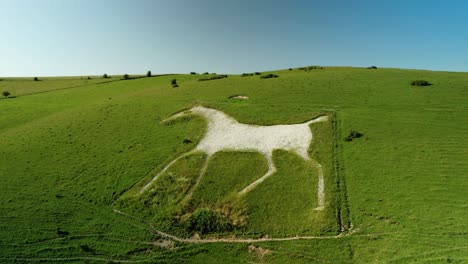 Alton-Barnes-iconic-white-horse-hillside-carving-chalk-figure-landmark-aerial-view-rising-above-English-landscape