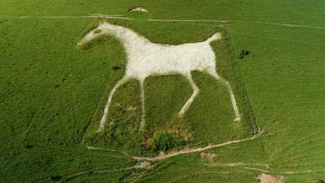 Alton-Barnes-iconic-white-horse-chalk-figure-countryside-landmark-aerial-view-push-in-towards-hillside