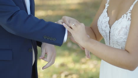 Bride-fixing-gold-bracelet-around-grooms-wrist-at-wedding-ceremony