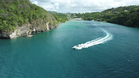 Speedboat-coming-out-of-Marigot-Bay,-captured-by-drone