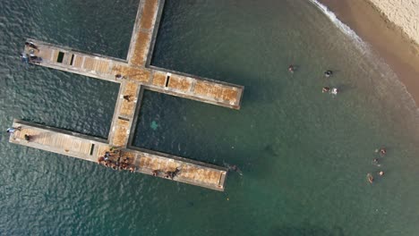 Local-kids-playing-on-dock-top-down-drone-footage