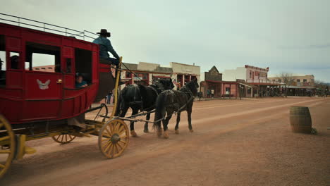 Red-horse-drawn-stagecoach-carrying-tourists-through-town-in-Tombstone-Arizona