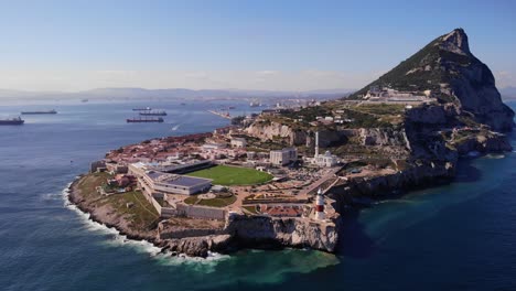 Rugbystadion-Und-Weiße-Moschee-Am-Europa-Point-Mit-Dem-Leuchtturm-über-Den-Klippen-Und-Im-Hintergrund-Schiffe,-Die-In-Der-Bucht-Von-Algeciras-Und-Dem-Oberen-Felsen-Von-Gibraltar-Vor-Anker-Liegen