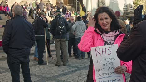 NHS-staff-member-being-interviewed-outside-Leeds-town-hall-on-NHS-staff-working-conditions-during-an-extinction-rebellion-protest-medium-close-up-Shot