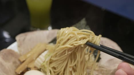 man-use-chocpstick-pick-ramen-japanese-noodle-ready-to-eat