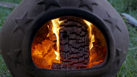 SLO-MO:-Burning-embers-in-a-terra-cotta-chimenea-during-late-evening