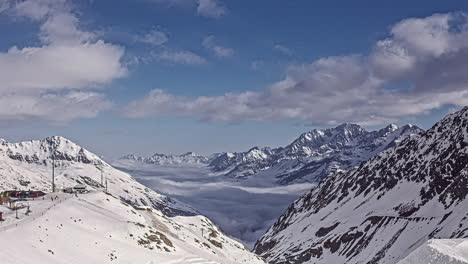 Time-lapse-shot-of-flying-clouds-over-snowy-austrian-Alps-Mountains-in-Kaunertal-Ski-Resort---Aerial-panorama-view