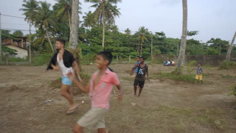 Mann-Spielt-Mit-Einheimischen-Kindern-Im-Dorf-Weligama,-Sri-Lanka