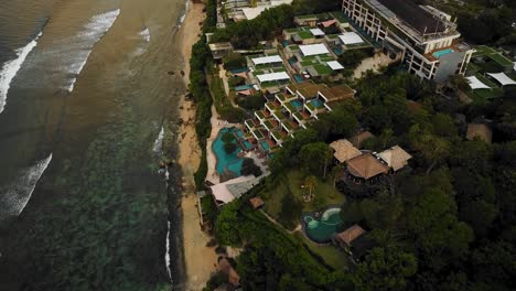 Beautiful-Bingin-beach-with-exotic-cliffs-houses-and-hotel-located-in-Bali,-Indonesia