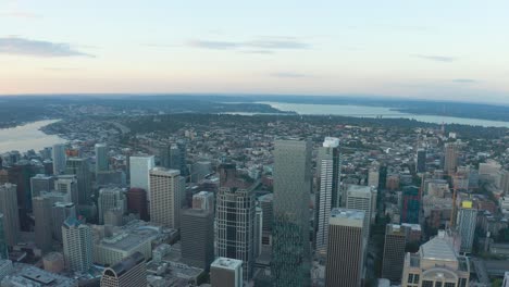 Wide-soaring-aerial-shot-of-Seattle's-downtown-skyscrapers-with-Lake-Union-and-Lake-Washington-off-in-the-distance