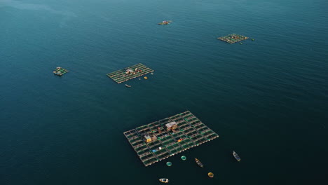 Fish-breeding-farms-floating-on-sea-on-coast-of-Vietnam,-aerial-panorama