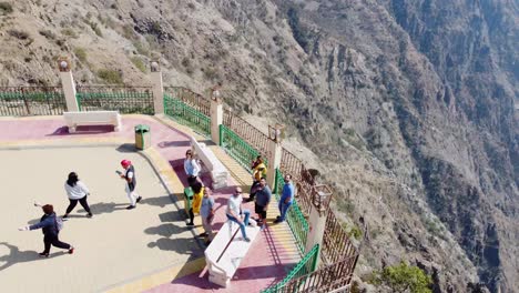 Aerial-view-around-a-group-of-tourists-at-a-viewpoint-on-top-of-the-Raghadan-Forest-Park,-in-sunny-Saudi-Arabia