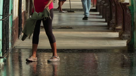 Woman-mopping-outside-in-the-evening-in-Havana,-Cuba