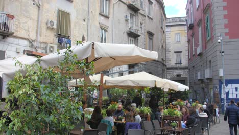Gente-Pasando-El-Rato-Y-Disfrutando-De-Sus-Bocadillos-Y-Cafés-En-La-Plaza-Piazza-Bellini-En-Nápoles,-Italia