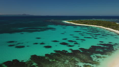 Aerial-tracking-shot-over-protected-cove-off-small-New-Caledonia-island