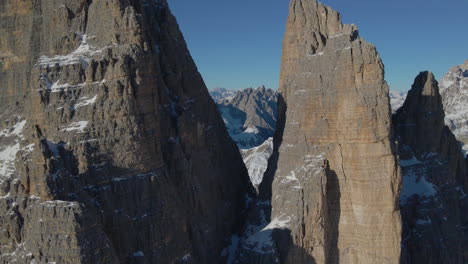 Luftaufnahmen-Zwischen-Drei-Zinnen-Und-Felsformationen-In-Südtirol-Zeigen-Eine-Verschneite,-Malerische-Tallandschaft